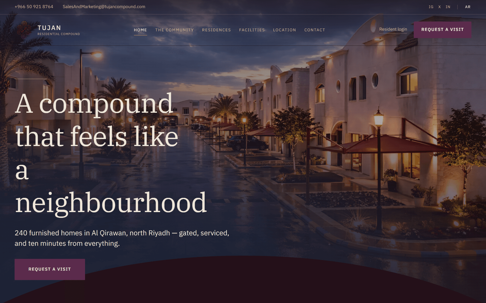 The Tujan Compound homepage: the headline "A compound that feels like a neighbourhood" over a photograph of the lit compound at dusk.